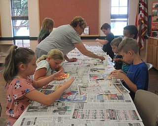 Neighbors | Jessica Harker.Children assisted by camp helpers worked on sand art at the Explorers Kitchen Chemist summer camp on July 19 at the MetroParks Farms.