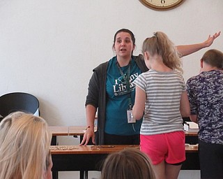 Neighbors | Jessica Harker .Librarian Renee Beverly organized a shark took necklace making event July 29 at the Austintown library in celebration of this years Shark Week.