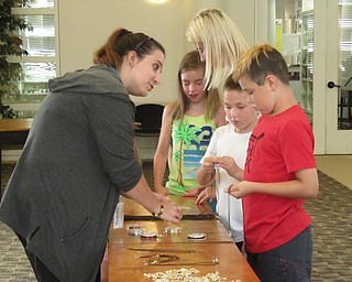 Neighbors | Jessica Harker .Community members selected supplies to create shark tooth necklaces with the help of librarian Renee Beverly July 29.