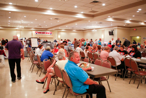 Attendees of the Slovak Fest eat, mingle, and look at the Slovak basket auction at Byzantine Center at the Grove on Sunday afternoon. EMILY MATTHEWS | THE VINDICATOR