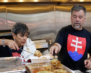 Lucille Esposito, left, of Summit County, and Bob Babnic, of Youngstown, scoop out halupki, or stuffed cabbage, at the Slovak Fest at Byzantine Center at the Grove on Sunday afternoon. EMILY MATTHEWS | THE VINDICATOR