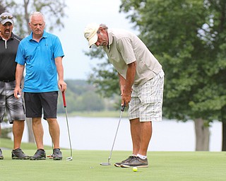 Steve Richman sinks a putt on  No. 18 at The Lake Club in Poland as from left Blase Cindric, Scott Russell and Doug Bleggi look on during Greatest Golfer Scramble championship.

