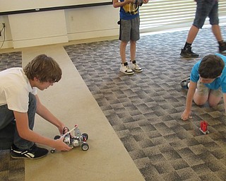 Neighbors | Jessica Harker .NIcholas Foster and Elijah Gattow showcase the robot that they built and programmed at the Austintown library's Techie Camp on Aug. 8.