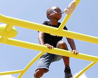 Emmanuel Robinson, 7, of the East Side, plays on a jungle gym at the new playground at Lincoln Knolls Community Park on Saturday.  EMILY MATTHEWS | THE VINDICATOR