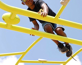 Emmanuel Robinson, 7, of the East Side, plays on a jungle gym at the new playground at Lincoln Knolls Community Park on Saturday.  EMILY MATTHEWS | THE VINDICATOR