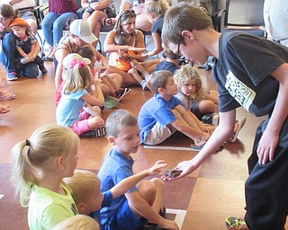 Neighbors | Jessica Harker .Children were able to pet a tree frog held by Chase at the Michael Kusalaba library July 29 during Mark's Ark live animal show.