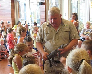 Neighbors | Jessica Harker .Children were able to pet a live alligator held by Mark Kohlhorst July 29 at the Michael Kusalaba library.