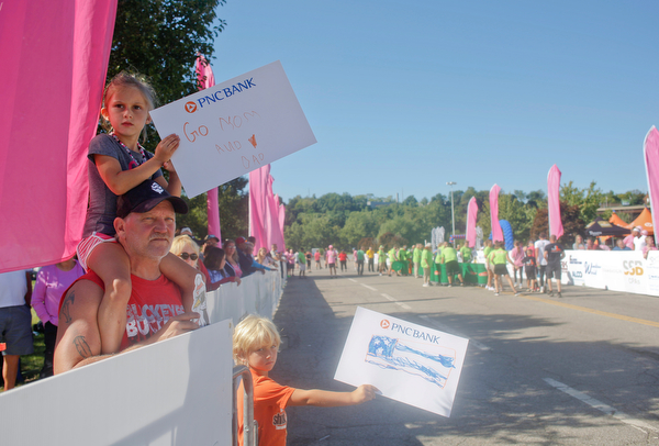 Mya Morgan, 5, of Cortland, sits on the shoulders of Tom Ayres, of Niles, while she and Chandler Ayres, 6, hold signs for Morgan's parents Andy and Ro Morgan during the 2019 Panerathon on Sunday morning. Andy finished in first for the open men's 10K with a time of 31:40.0 and Ro came in first for the open women's 10K with a time of 37:31.8. EMILY MATTHEWS | THE VINDICATOR