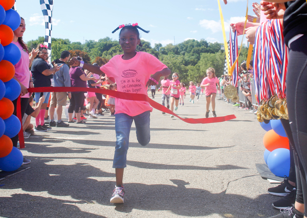 Nevaeh Taltoan, 7, of Girard, crosses the finish line first in the 7 year old girls division of the Kids Run during the 2019 Panerathon on Sunday morning. EMILY MATTHEWS | THE VINDICATOR