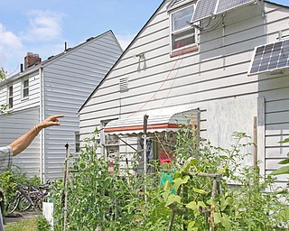 George Hauman shows off the solar panels atop his Hilton Avenue home, where he’s lived “off the grid” since 2013. Hauman said he also used a rainwater-collection system to circulate water through the home. But the city, in 2017, “red-tagged” the home for not having the three legally required utilities. He’s now suing the city in federal court.

