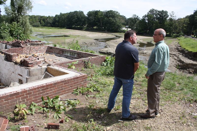 Randy Smith, Trumbull County Engineer, left, and state Rep. Michael O'Brien stand near the home being demolished and the area where the Kinsman Lake causeway washed away July 20. There was a news conference Monday morning to announce the the start of repairs on the causeway.