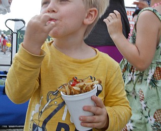  ROBERT K.YOSAY  | THE VINDICATOR..The 173rd version of the Canfield Fair opened Wednesday to mid 70 degrees, sun, and fries and sausage sandwiches...good fries.. a  staple as Ace McCall enjoys a fry with vinegar of course