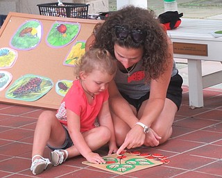 Neighbors | Jessica Harker .Adriana worked on a ladybug puzzle with her mother at the monthly Tales for Tots event at Fellows Riverside Gardens on Aug. 16.