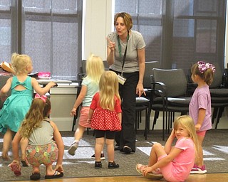 Neighbors | Jessica Harker .Librarian Nikki Puhalla sang "Five Little Monkeys" with 10 children gathered at the Canfield library on Aug. 14 for the Read and Make event.