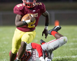 Cardinal Mooney's Zyere Rodgers runs with the ball as Chaney's Key-Shaun Davis tries to tackle him during their game at Rayen Stadium on Thursday. EMILY MATTHEWS | THE VINDICATOR