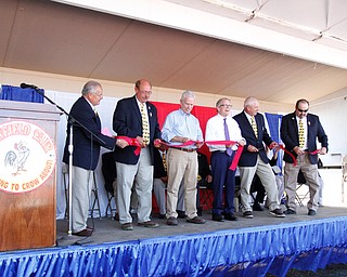         ROBERT K.YOSAY  | THE VINDICATOR..The 173rd version of the Canfield Fair official ribbon cutting as Fred Moran 84 jumped from the plane to help publicize Veterans Jobs..George Roman- David Dickey  rep Bill Johnson gov Mike DeWine- Ward Campbell and Frank Paden   all with the board of directors
