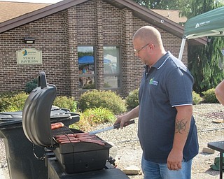 Neighbors | Jessica Harker .Todd Shaffer cooked hotdogs to give out to community members who spent more than $5 at the Austintown Farmers Market August 19.